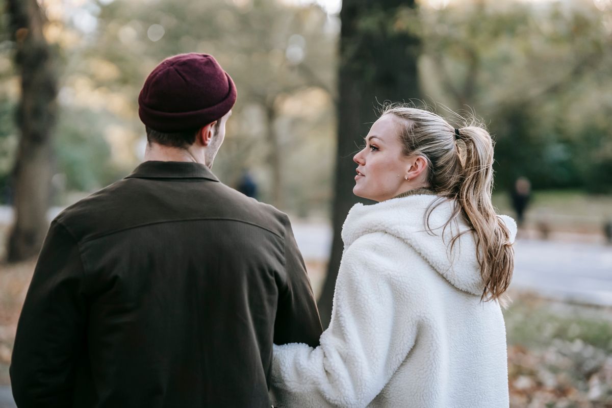 A couple talking while strolling through a leafy autumn park