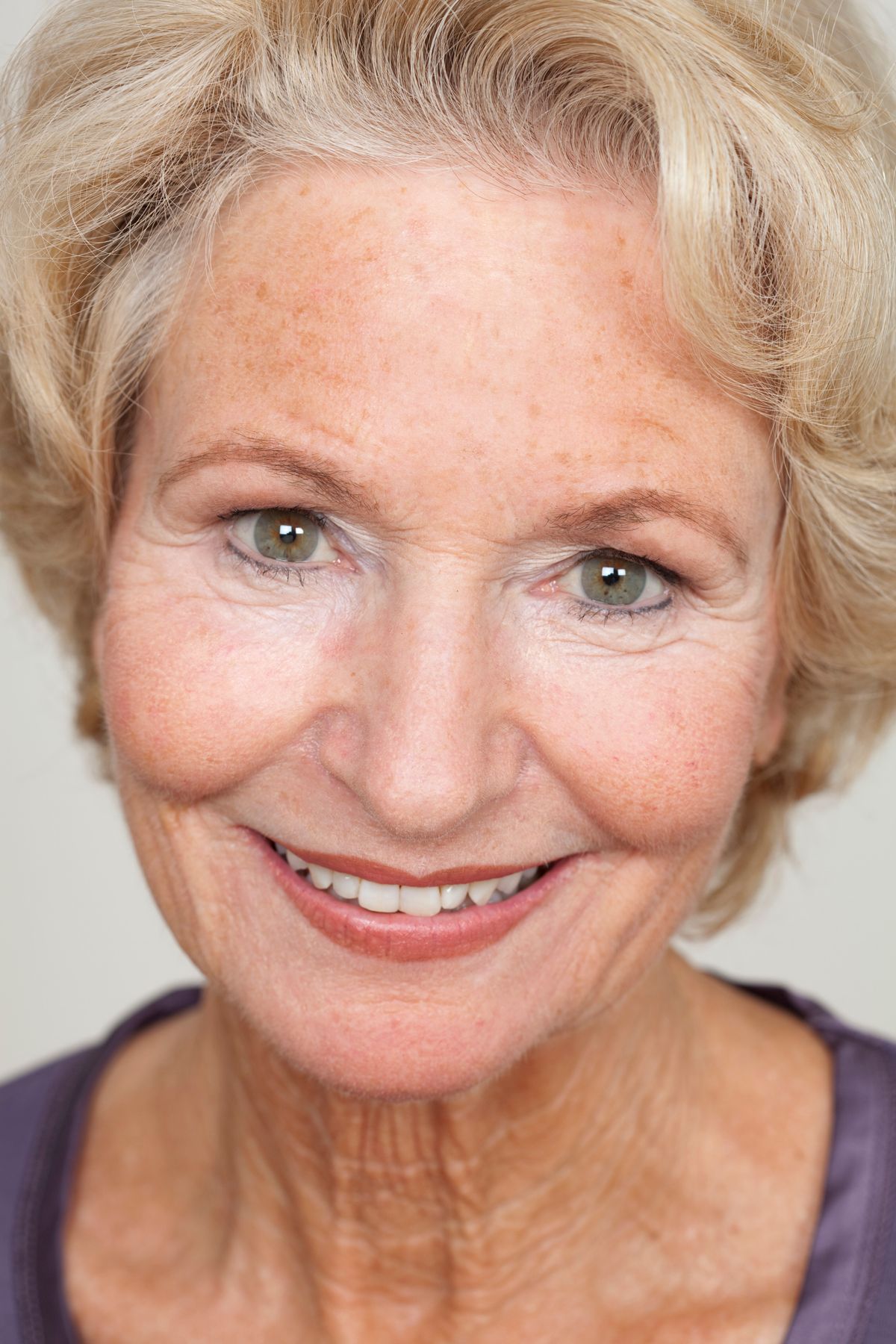 Portrait of a warm, gently smiling elderly woman in soft natural light