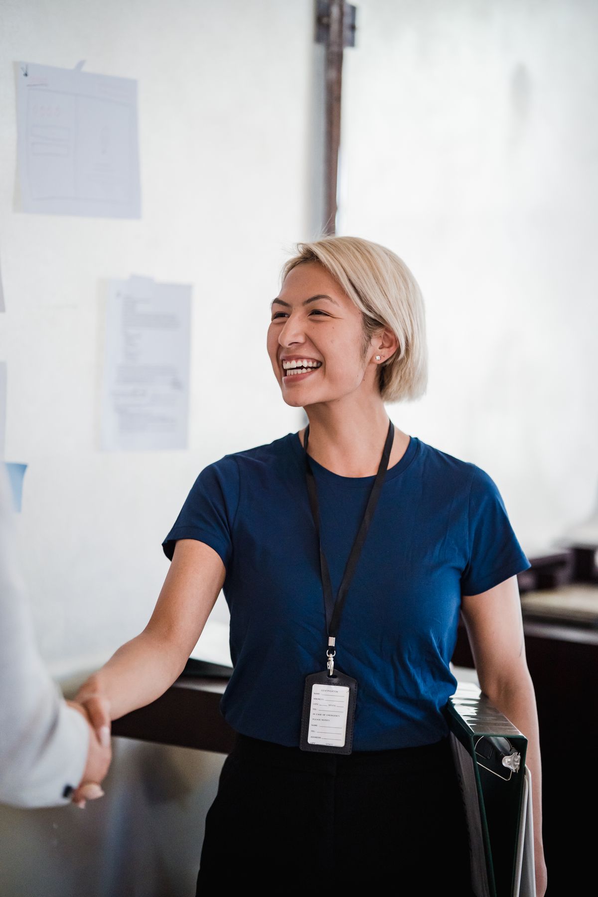 A friendly professional woman shaking hands during a meeting, representing a personal matchmaking consultation