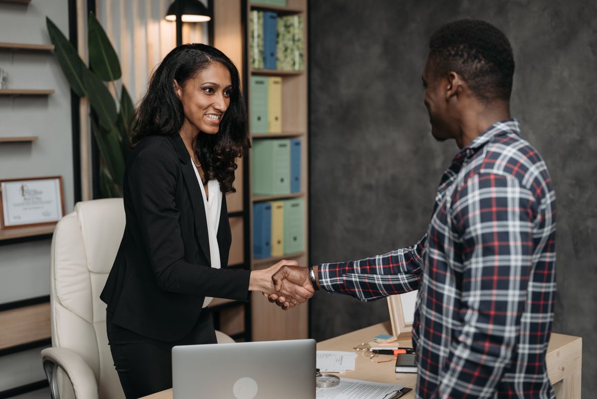 Two professionals shaking hands in a modern office, representing a careful, trusted vetting process