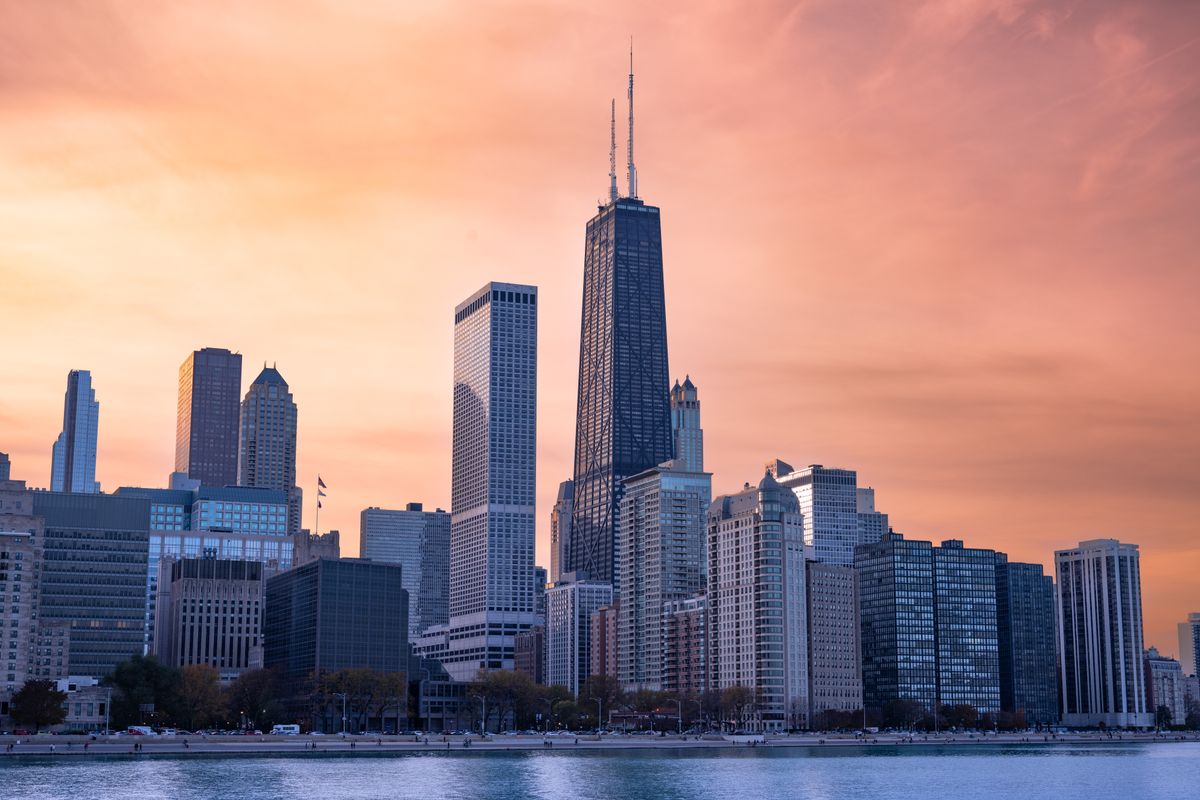 Chicago's downtown skyline at sunset reflected over the waterfront, anchoring the local Chicagoland setting