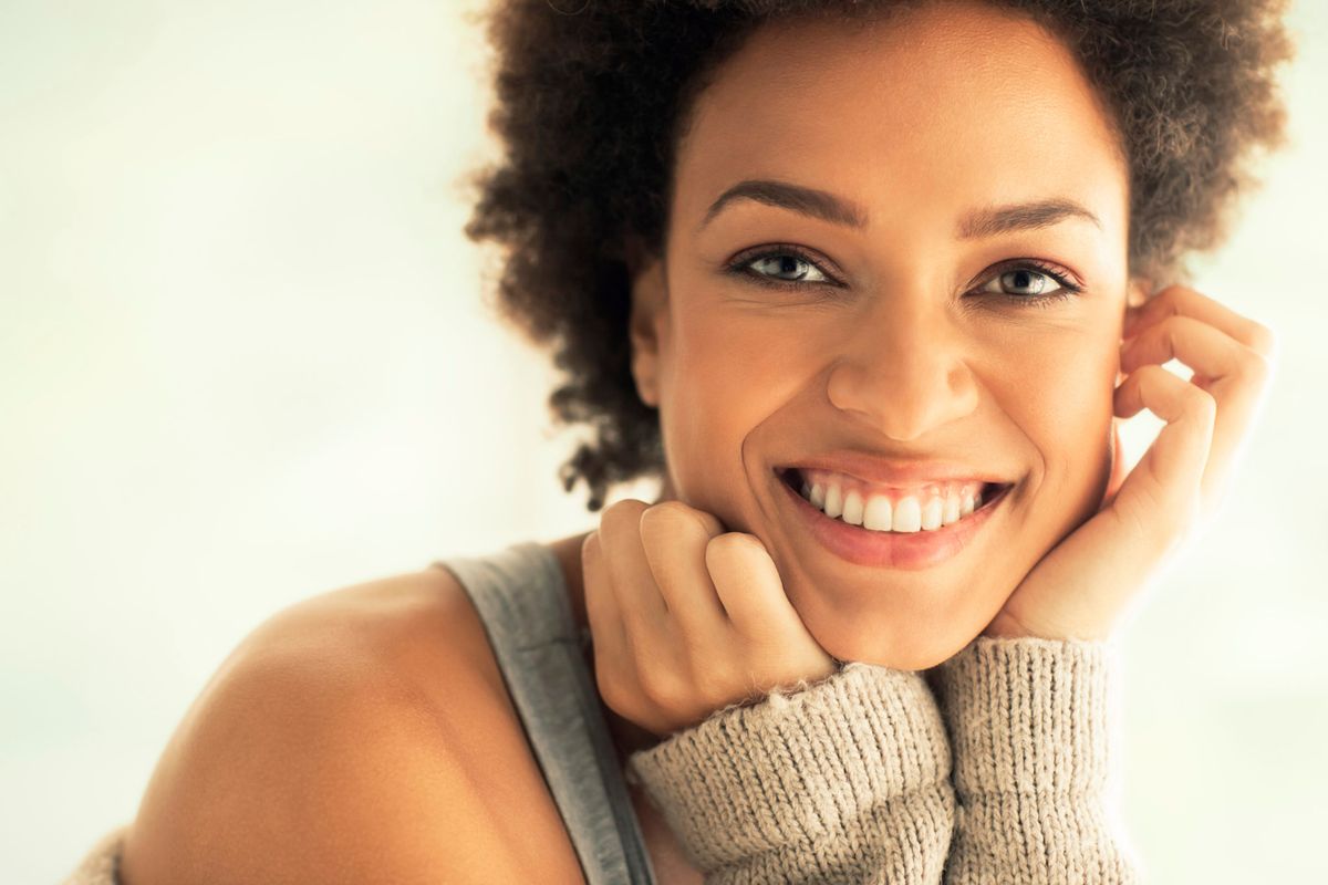A confident, relaxed woman smiling warmly, reflecting the reassurance of a safely screened dating experience