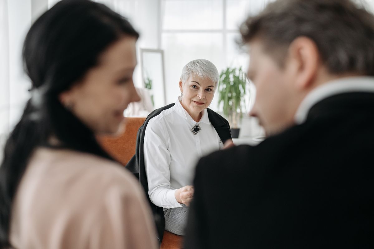 A couple in a warm one-on-one consultation with an advisor in a modern office